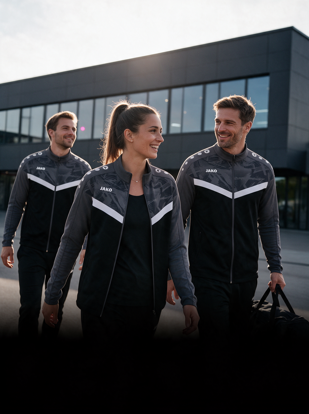 Vereinsmitglieder in schwarzen JAKO-Trainingsjacken bei der gemeinsamen Ankunft.