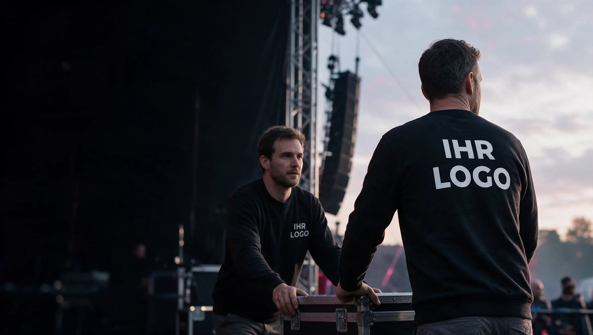 Team bei der Vorbereitung eines Events in schwarzen Sweatshirts mit weißem IHR LOGO auf Brust oder Rücken.