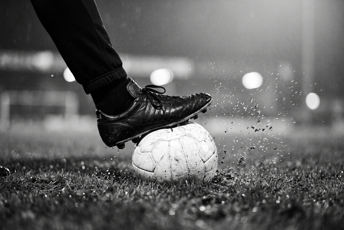 Fußballschuh auf dem Ball unter Flutlicht